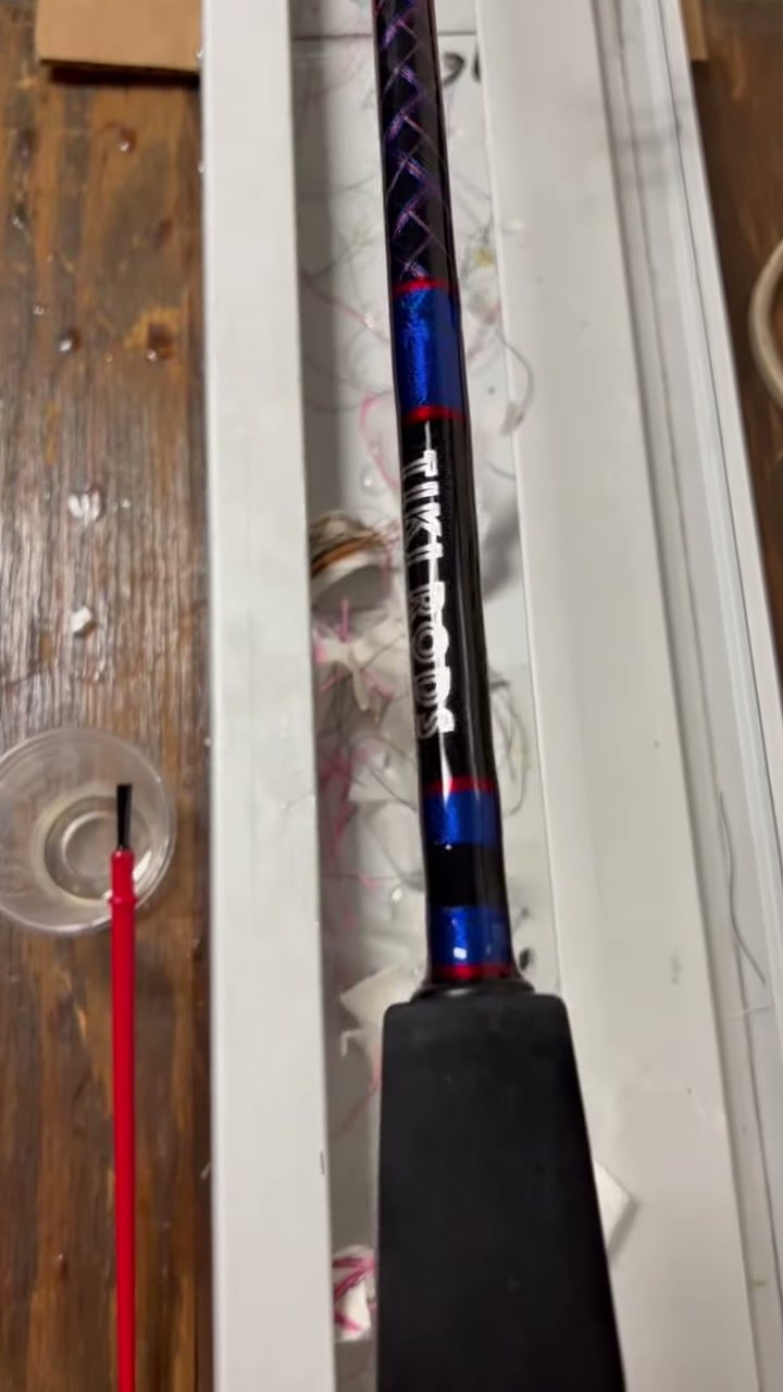 A rod on the shop rack with a blue, red and white decorative butt wrap