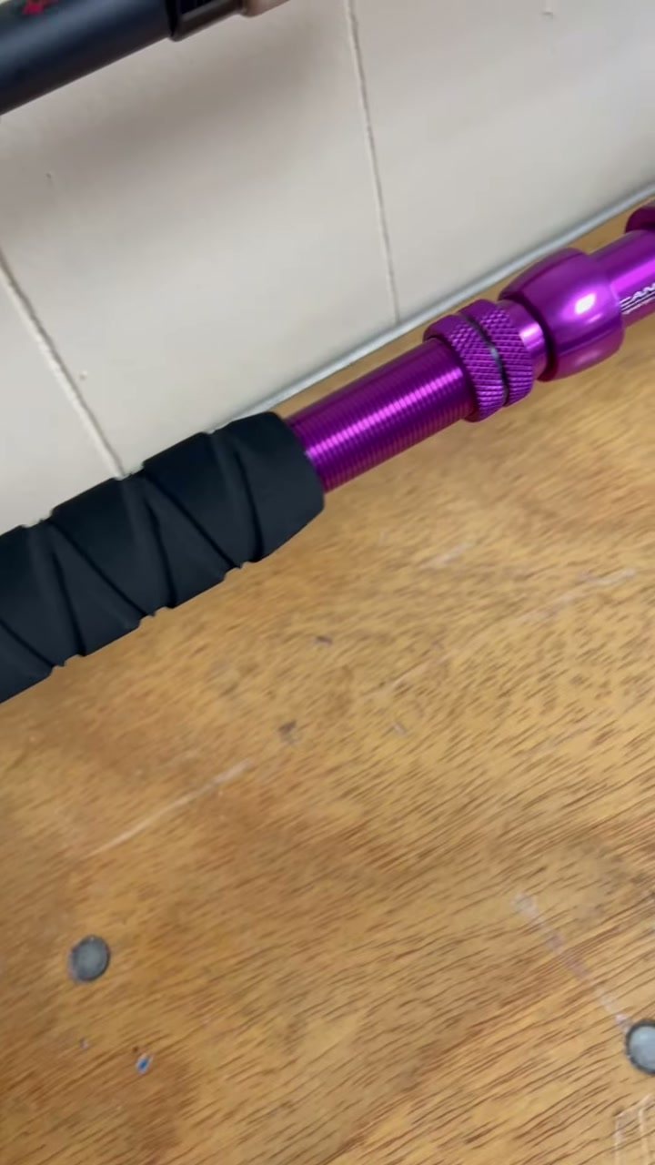 A purple anodised reel seat above a black grip wrap
